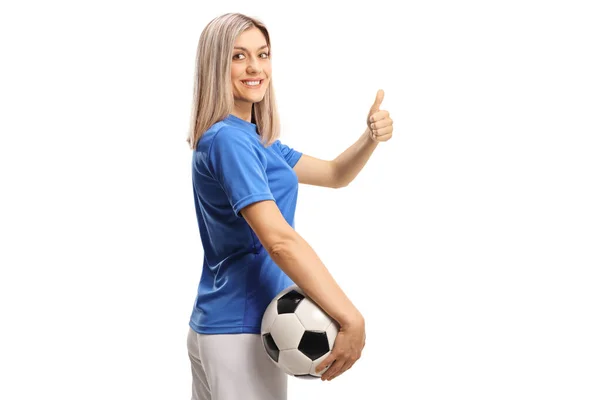 白い背景に隔離された親指を示すボールを持つ女性サッカー選手 — ストック写真