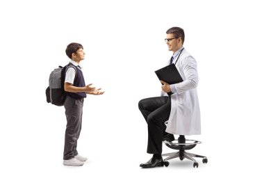 Beyaz arka planda izole edilmiş bir sandalyede oturan bir erkek doktorla konuşan bir öğrencinin tam boy profil fotoğrafı.