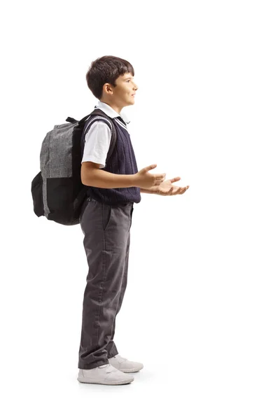 男の子が立ち 手でジェスチャーし 白い背景に隔離されたバックパックを運ぶフル長さのプロフィールショット — ストック写真