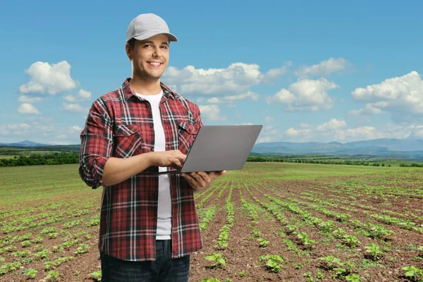 Young Man Checkered Shirt Holding Laptop Computer Looking Camera Field — Stock Photo, Image