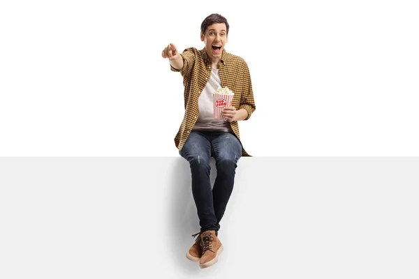 Joven Riendo Señalando Panel Comiendo Palomitas Aisladas Sobre Fondo Blanco — Foto de Stock