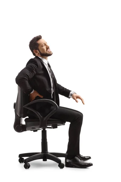 痛みを伴う腰を持って仕事でプロの男と白い背景に隔離された椅子に座って — ストック写真
