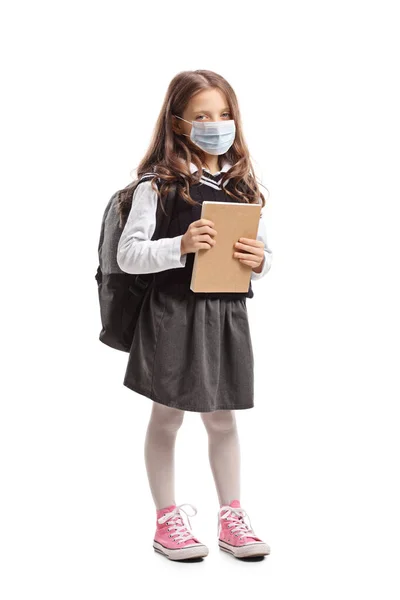 本を持っている小さな女の子の完全な長さの肖像画と身に着けています保護顔マスク隔離された白い背景 — ストック写真
