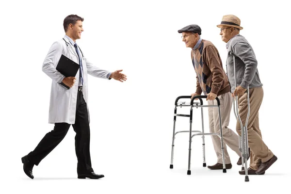 Male Doctor Walking Greeting Elderly Patients Walkers Crutches Isolated White — Stock Photo, Image