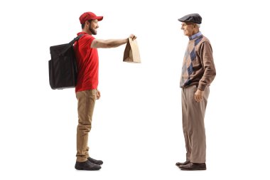 Bir teslimatçının beyaz arka planda yaşayan yaşlı bir adama yemek dağıtırken tam boy profil fotoğrafı.