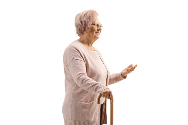 白い背景に孤立した手で杖とジェスチャーで立っている高齢女性の完全な長さのショット — ストック写真