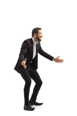 Takım elbiseli, elleri beyaz arka planda yalnız gezen mutlu genç adam.