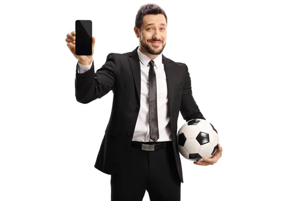 Hombre Con Traje Negro Mostrando Smartphone Sosteniendo Una Pelota Fútbol —  Fotos de Stock