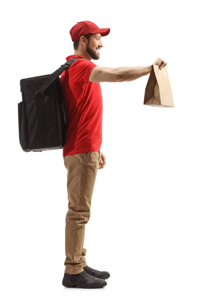 白い背景に隔離された食べ物を提供する袋を持つ男の完全な長さのプロフィールショット — ストック写真