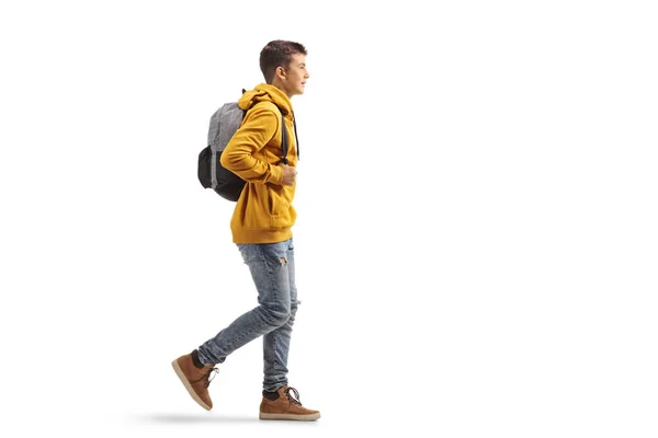 フル長さプロフィールショットの男十代の学生でA黄色パーカー歩行孤立した上に白の背景 — ストック写真