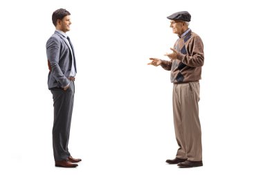 Beyaz arka planda, takım elbiseli ve kravatlı bir gençle konuşan yaşlı bir adamın tam boy profil çekimi.