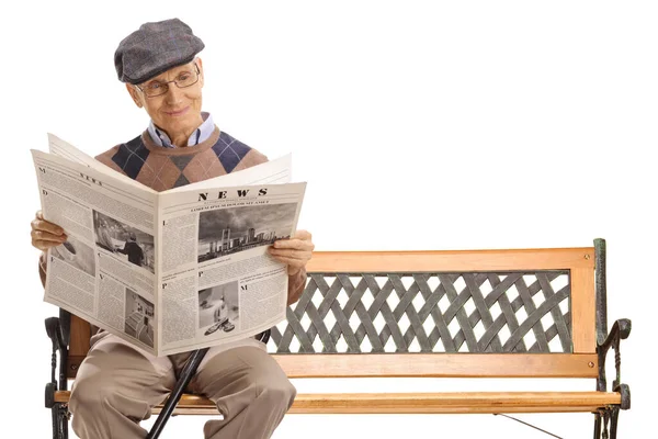白い背景に隔離されたベンチで新聞を読んでいる老人の完全な長さのショット — ストック写真