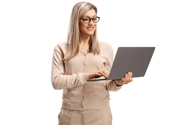 グラスを持ち 白い背景に隔離されたラップトップコンピュータで作業している陽気な若い女性 — ストック写真