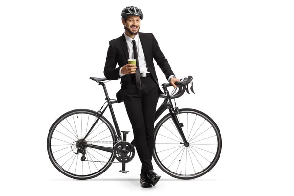 自転車にもたれかかるヘルメットと白い背景に隔離されたテイクアウトコーヒーを持つビジネスマンの完全な長さの肖像画 — ストック写真