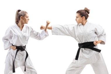 Kimonolu genç kadınlar beyaz arka planda karate yapıyorlar.