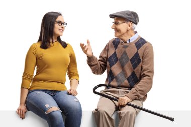 Panelde oturan yaşlı bir adam beyaz arka planda izole edilmiş genç bir kadınla konuşuyor.