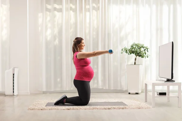 Těhotná Žena Cvičení Modrými Činky Před Televizí Doma — Stock fotografie