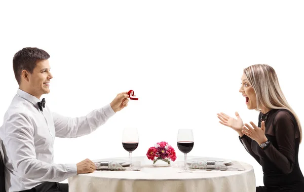 白い背景に隔離されたレストランのテーブルで女性との結婚を提案する男 — ストック写真