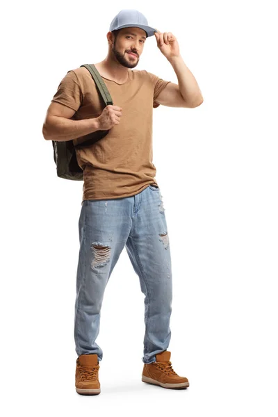 一个年轻男子的全长肖像 他背着背包 穿着撕破的牛仔裤 头戴白色背景的帽子 — 图库照片