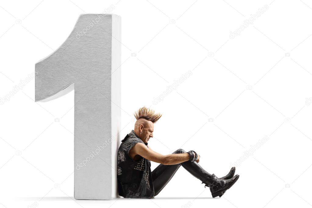 Punk rocker with a mohawk sitting on the ground and leaning on a big number one isolated on white background