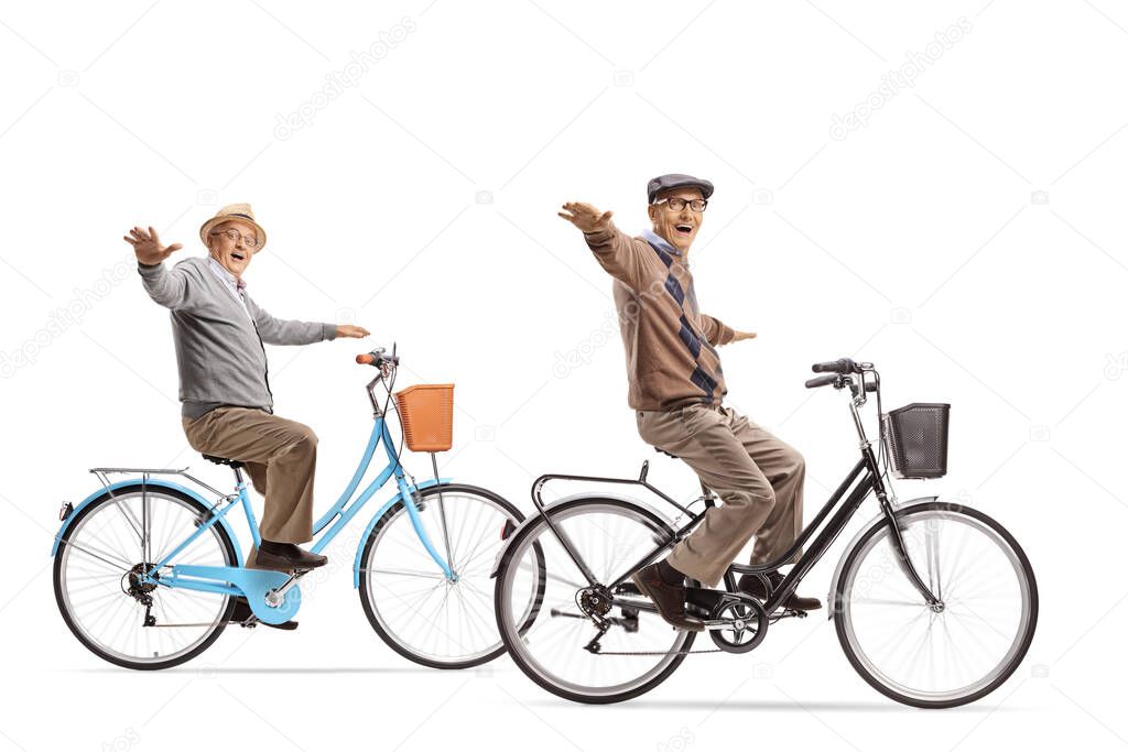 Two elderly men riding bicycles with arms wide open isolated on white background