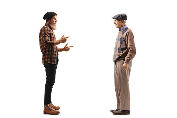 Full length profile shot of a hipster bearded guy talking to an elderly man isolated on white background