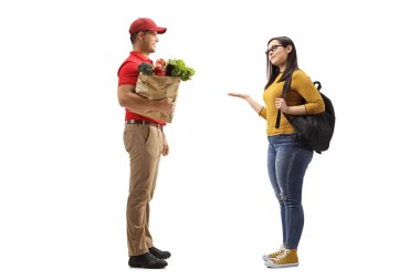 Beyaz arka planda izole edilmiş bir kız öğrenciye bir torba erzak götüren bir adamın tam boy profil fotoğrafı.
