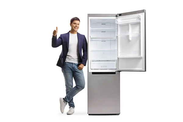 Портрет Молодого Человека Джинсах Костюме Опирающегося Пустой Открытый Холодильник Показывающего — стоковое фото
