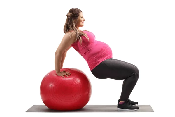 用白色背景隔离的健身球进行运动的孕妇的档案照片 — 图库照片