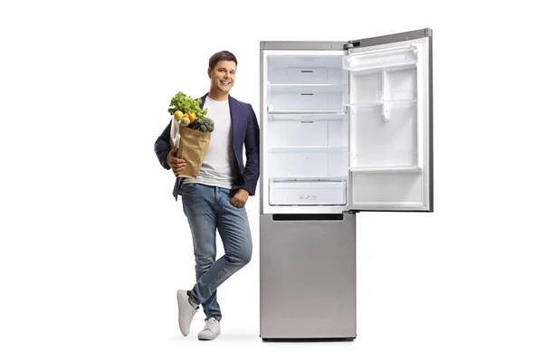 봉지를 배경에 떨어져 냉장고에 기대고 남자의 — 스톡 사진