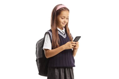 Üniformalı kız öğrenci beyaz arka planda izole edilmiş bir cep telefonu kullanıyor.