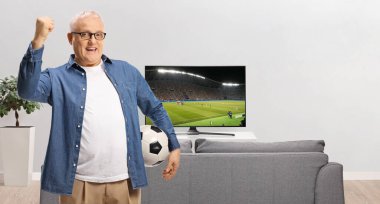 Televizyonda futbol maçı izleyen ve tezahürat yapan bir adam.