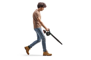 Beyaz arka planda izole edilmiş bir yaprak üfleyicisi kullanan genç bir adamın tam boy profil çekimi