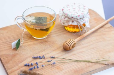 Bir fincan çay, lavanta, bir kavanoz bal bir ahşap tahta üzerinde durmak. Parlak tonlar. Rahat. Bahar. Isı. Yaz.