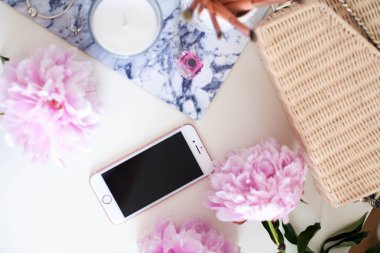 Peonies. Pembe peonies buket, mum, hasır çanta, eşarp, parfüm, mücevher, beyaz masa üzerinde telefon giyinme masası Spring Cozy