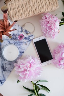 Peonies. Pembe peonies buket, mum, hasır çanta, eşarp, parfüm, mücevher, beyaz masa üzerinde telefon giyinme masası Spring Cozy
