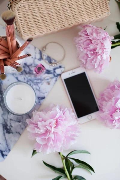 Peonies. Pembe peonies buket, mum, hasır çanta, eşarp, parfüm, mücevher, beyaz masa üzerinde telefon giyinme masası Spring Cozy