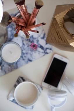 Bir fincan kapuçino, kozmetik, çiçekler, kostüm takı beyaz bir tablo. Tuvalet masası. Rahat. Bahar