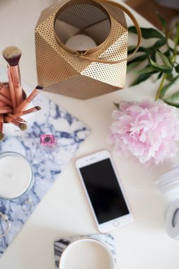 Bir fincan kapuçino, kozmetik, çiçekler, kostüm takı beyaz bir tablo. Tuvalet masası. Rahat. Bahar