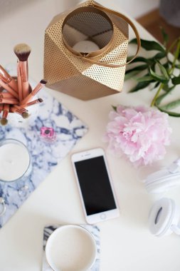 Bir fincan kapuçino, kozmetik, çiçekler, kostüm takı beyaz bir tablo. Tuvalet masası. Rahat. Bahar