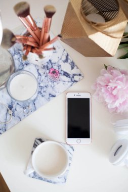Bir fincan kapuçino, kozmetik, çiçekler, kostüm takı beyaz bir tablo. Tuvalet masası. Rahat. Bahar