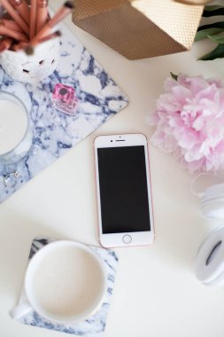 Bir fincan kapuçino, kozmetik, çiçekler, kostüm takı beyaz bir tablo. Tuvalet masası. Rahat. Bahar