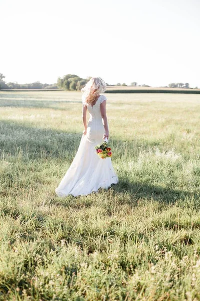 太陽の下で美しい花嫁の肖像画 ウェディング ドレスの若い幸せな女は フィールドで歩いています 居心地の良い — ストック写真