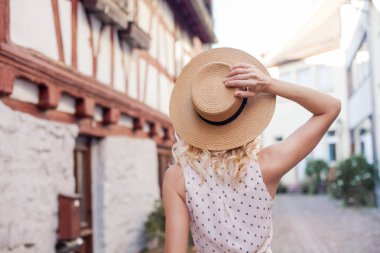 Şapkalı güzel bir genç kadın Avrupa şehirde yürüyüş. Mutlu kız portresi. Yaz. Isı. Şehir.