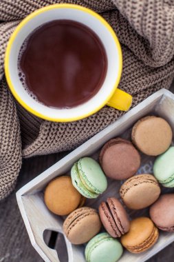 Bir fincan sıcak çikolata, kurabiye, ahşap bir masa üzerinde bir örme kazak. Sonbahar. Kış. Rahat.