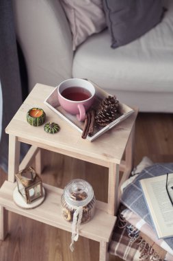 Kareli, bir fincan sıcak çay, Sonbahar dekorasyonu, bir kitap, bir ahşap sandalye üzerinde bir kabak. Rahat, Sonbahar dekorasyonu. Sonbahar iç, kanepe. Sonbahar. Kış.