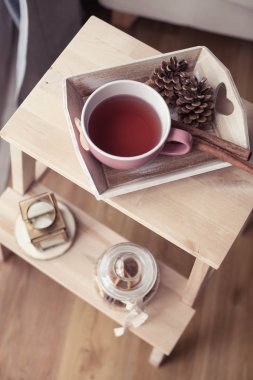 İskoç şalılar. Bir fincan çay. Sonbahar rahat iç. Bir tahta sandalyede bir yığın sıcak battaniye var. Mumlar, yaprakları, koniler, sepet, tarçın. Kitap ve gözlük. Sonbahar.