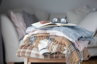 İskoç şalılar. Sonbahar rahat iç. Bir tahta sandalyede bir yığın sıcak battaniye var. Kitap ve gözlük. Sonbahar. Kış.