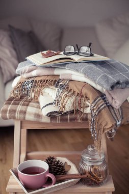 İskoç şalılar. Sonbahar rahat iç. Bir tahta sandalyede bir yığın sıcak battaniye var. Kitap ve gözlük. Sonbahar. Kış.
