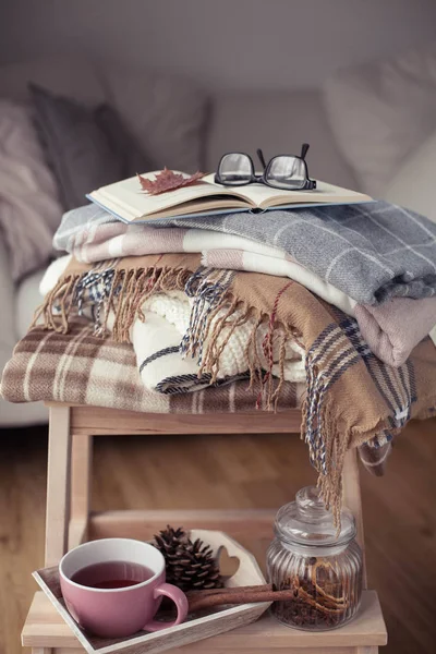 İskoç şalılar. Sonbahar rahat iç. Bir tahta sandalyede bir yığın sıcak battaniye var. Kitap ve gözlük. Sonbahar. Kış.